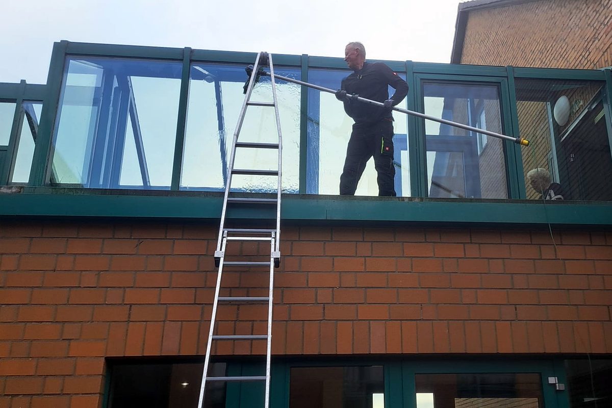 Fensterreinigung an einer Glasfassade im Obergeschoss